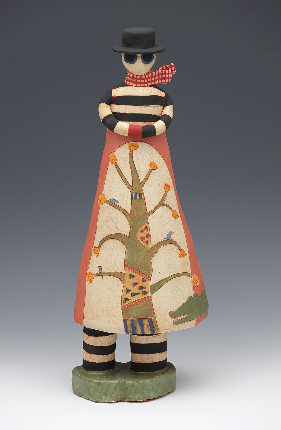 Figure in tree-design garment, sunglasses, scarf and hat